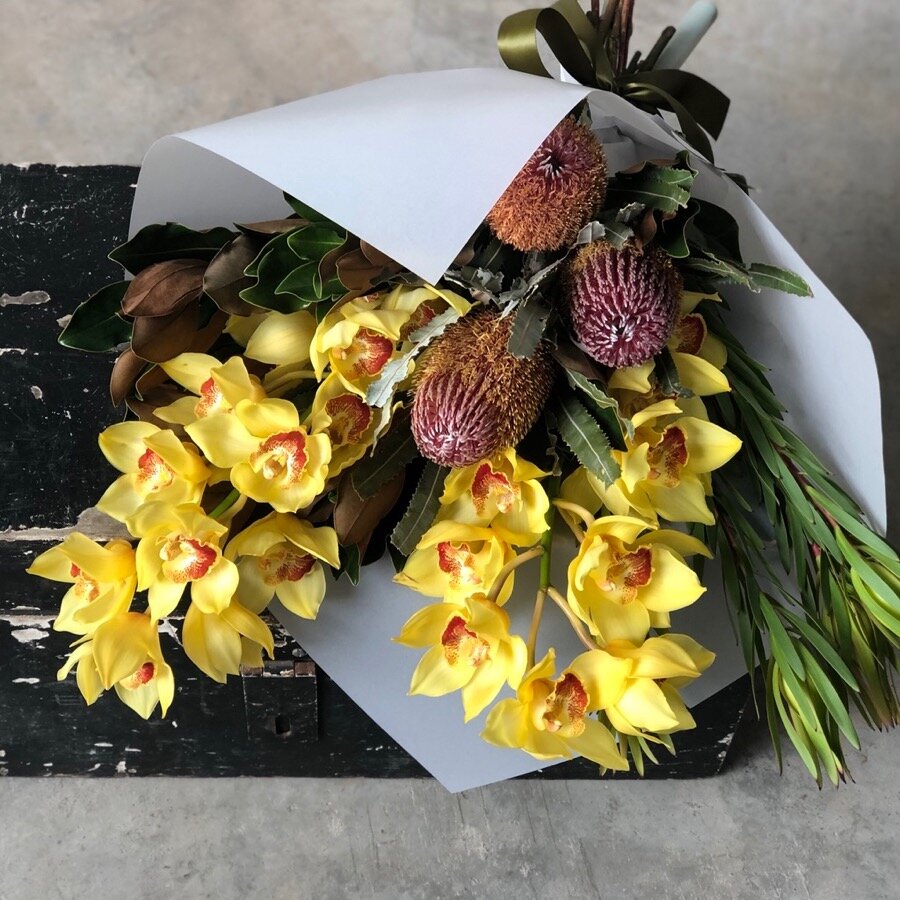 stunning beija flor bouquet of yellow and red flowers in a white wrap