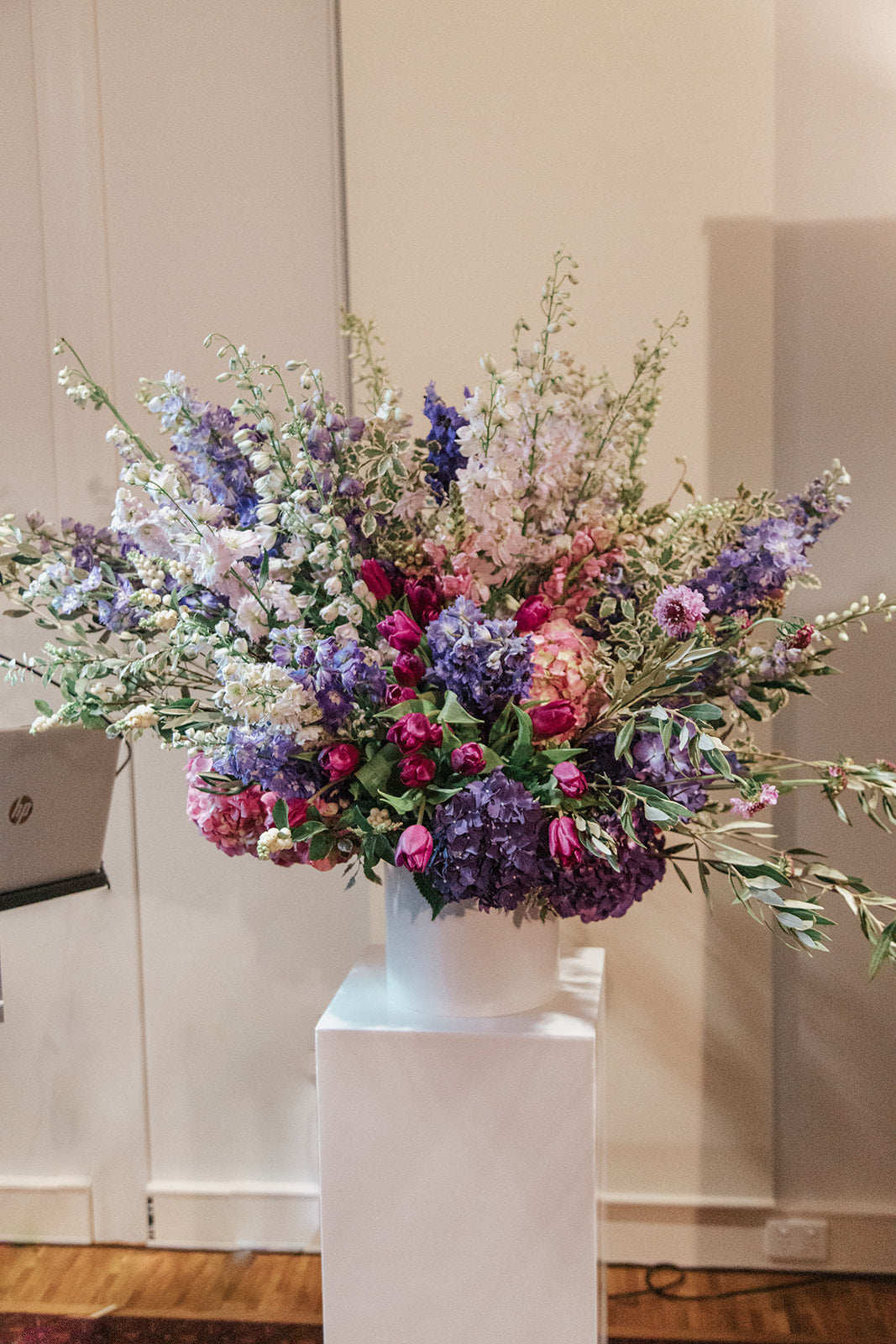 white vase filled with lots of purple and white flowers