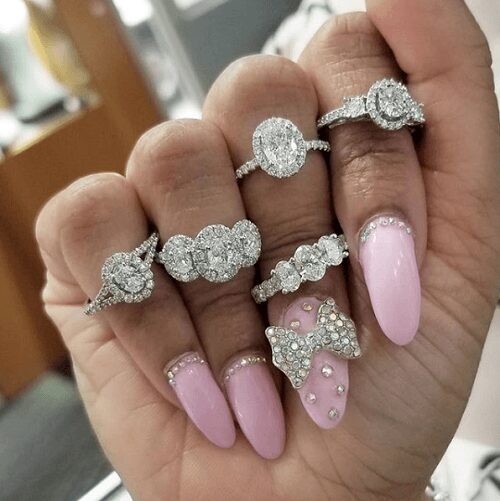 Deana holding up different styled diamond rings on all fingers.