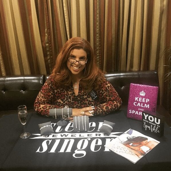 Deana at a table with an "I hate Steven Singer" table cloth.
