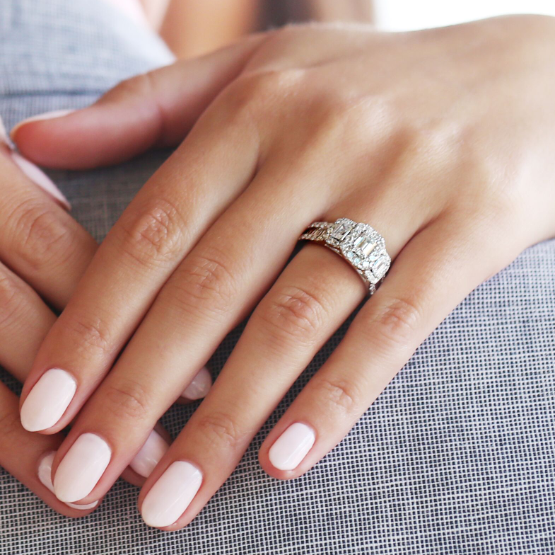 A woman showing a step cut diamond ring giving an antique look.