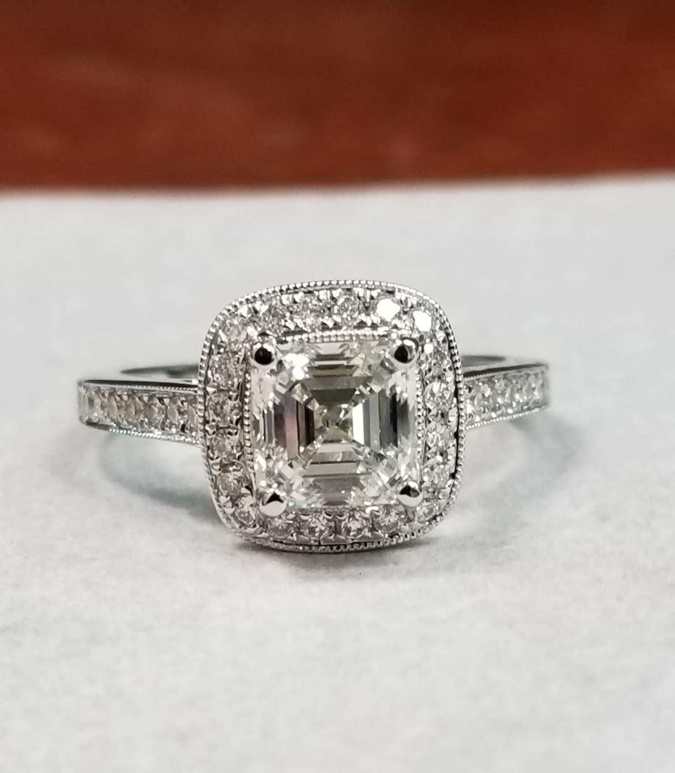 A close up of a diamond ring with a step cut diamond.
