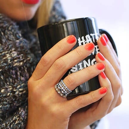 A woman holding an "I hate Steven Singer" mug showing off her stackable rings.