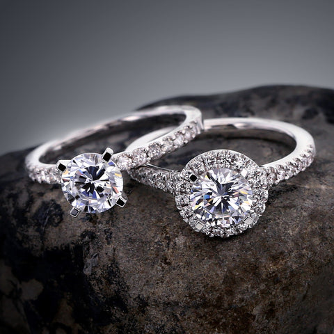 two classic style white gold engagement rings on a rock.