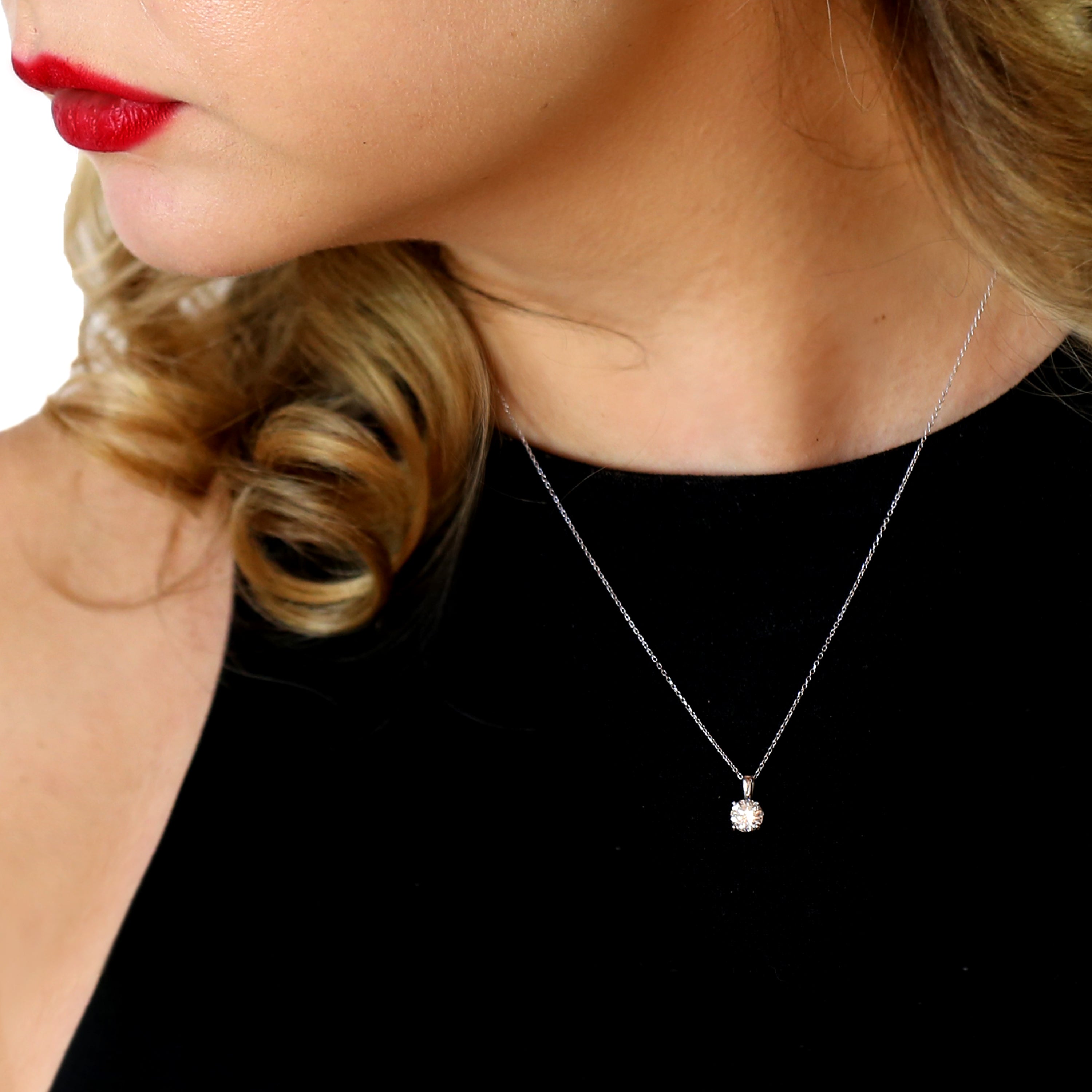 A blonde woman with a black shirt wearing one of our solitaire pendant necklaces.