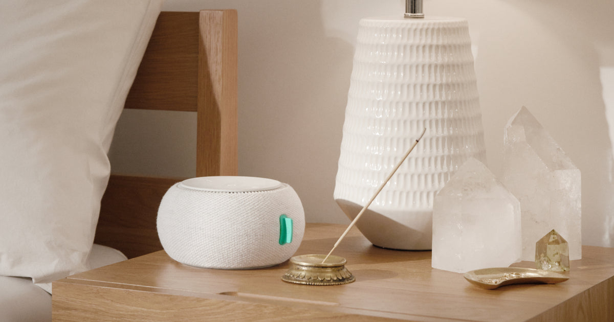 Picture of T&N White Noise Machine sitting on top of a nightstand next to crystals and a lamp