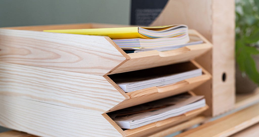 Wooden in-tray on student's desk, filled with notes