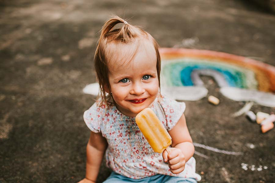 child in photo shoot eating poscicle