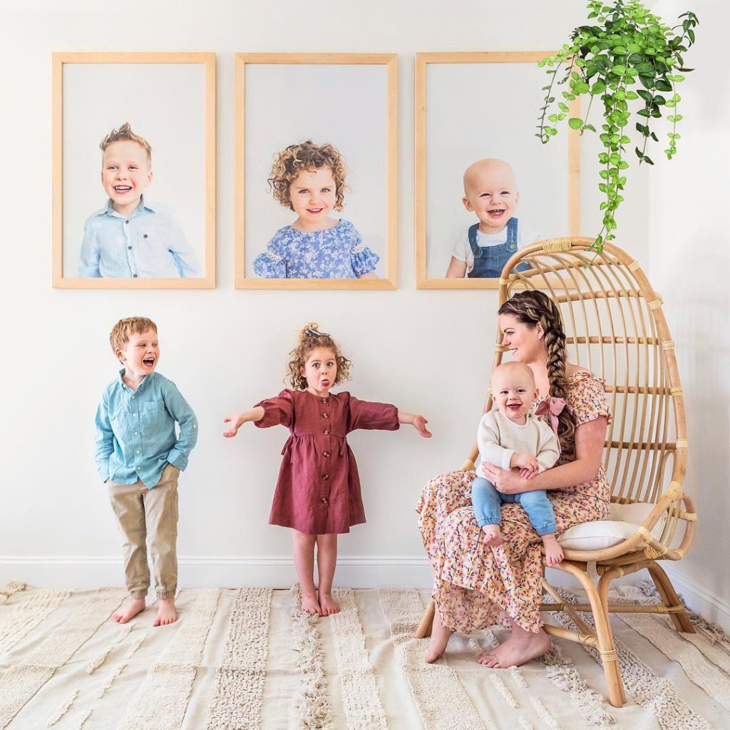 kids with their photos on wall