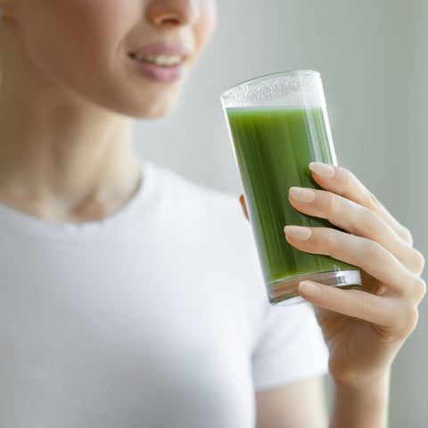 woman drinking green juice