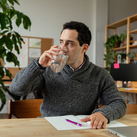 a person drinking water at a desk