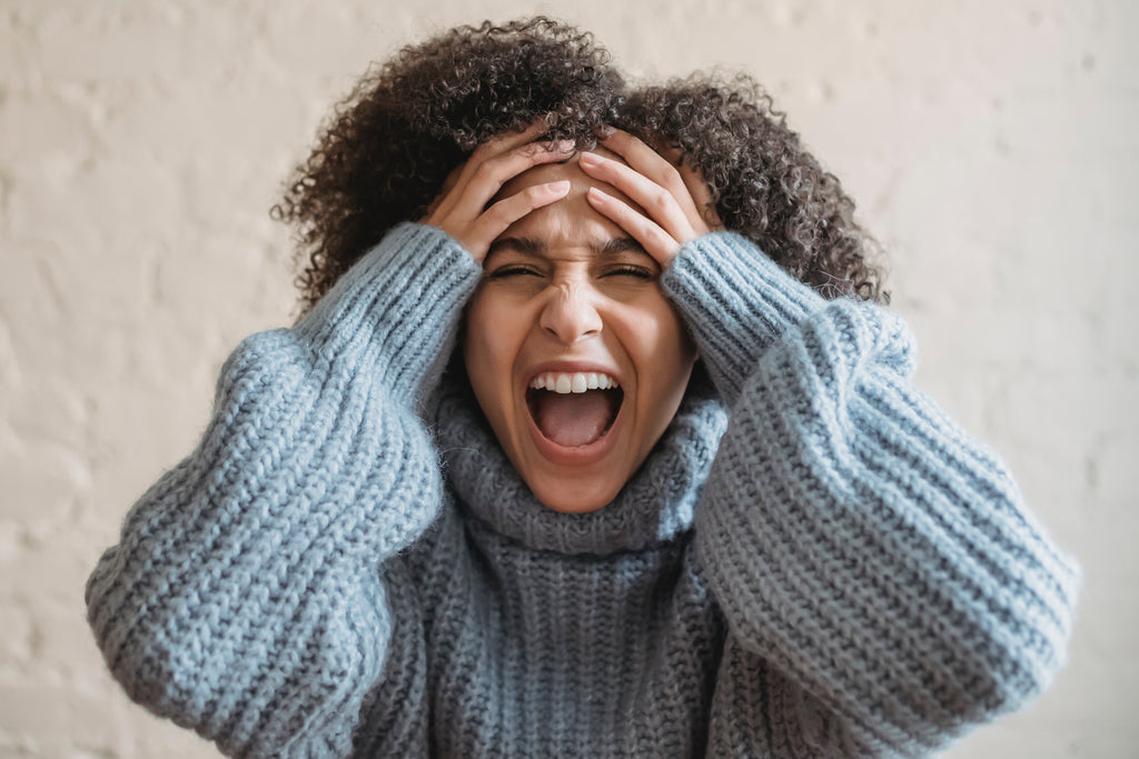 women with hands on head screaming