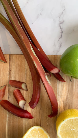 Fresh rhubarb and green apples on a wooden board