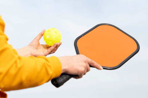 Pickleball Player Holds Pickleball Paddle and Ball