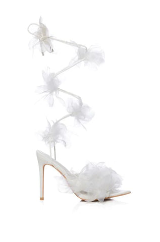 white open toe heels with tulle accent on front and white wrap up cords with tulle flower accents along the strings