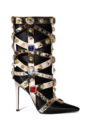 Black knee high boots with a stiletto heel, gold encasing, and colorful rhinestone gem embellishment