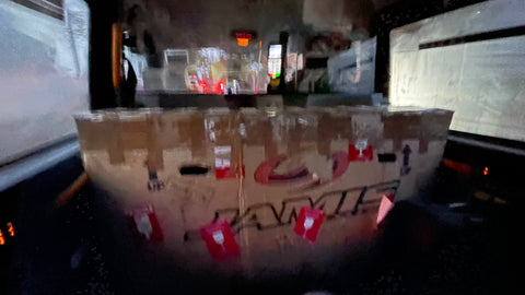 blurry image of cardboard bike box inside a london black taxi