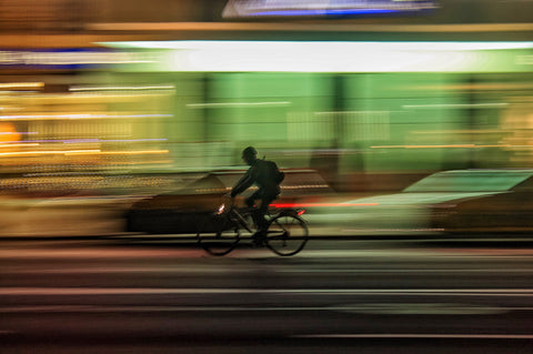 A man cycling through a city at night