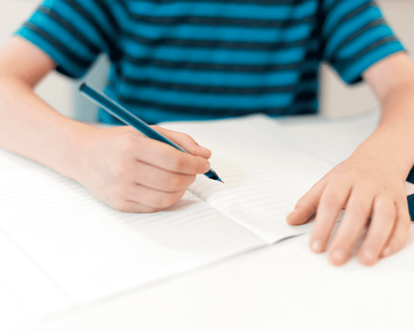 2nd grader writing on his journal