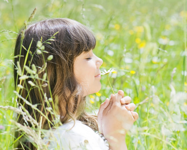 little girl smelling a flower