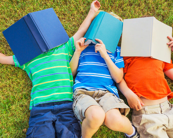 kids lying down with books covering their faces