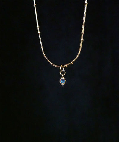 Aquamarine March Birthstone on a beaded gold filled chain with a black background.