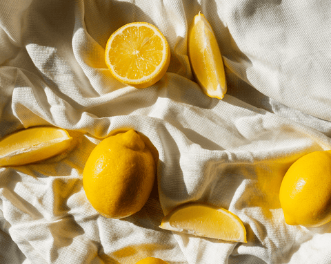 a flat lay image of lemons, full and sliced place atop a linen cloth