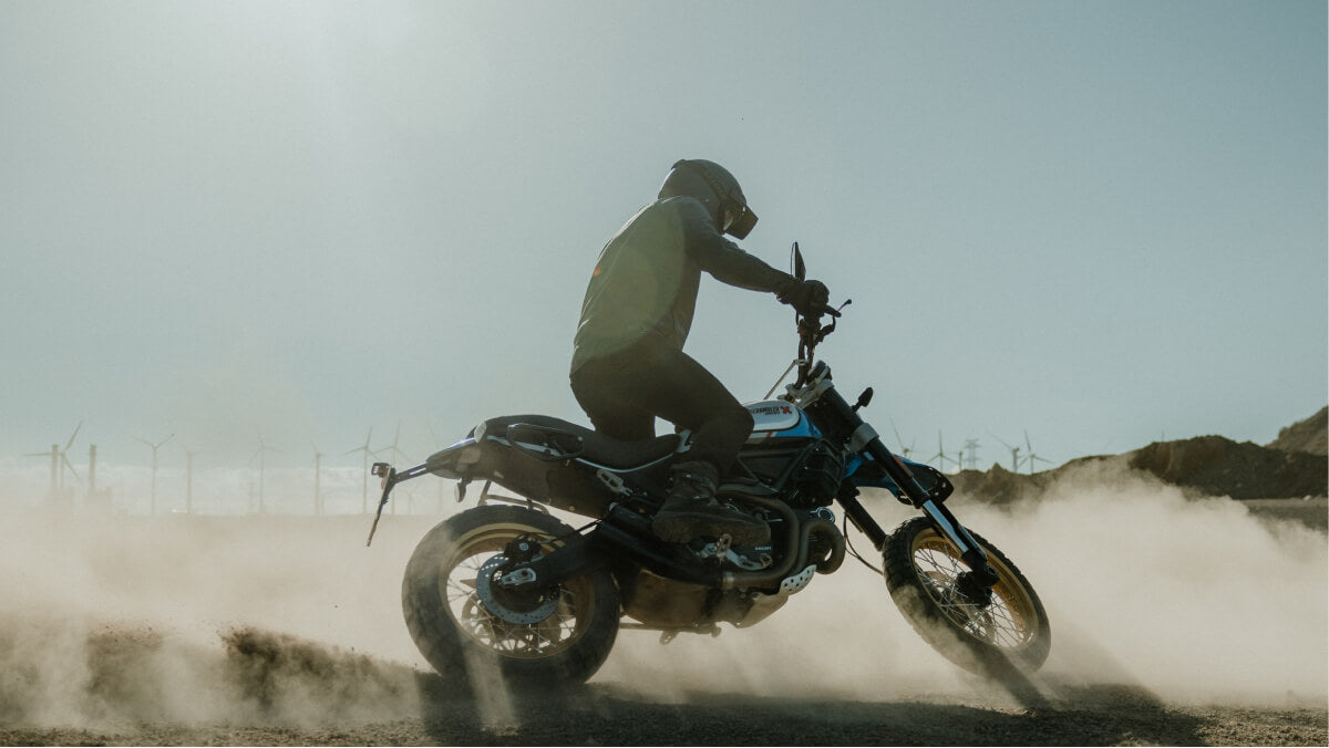 a man riding on a desert in leather motorcycle jacket from Rebelhorn - Runner III