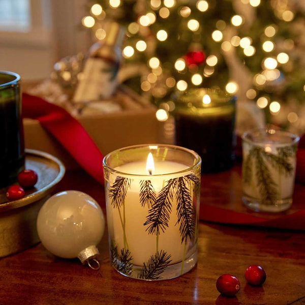 Thymes Frasier Fir Candle Burning Near A Christmas Tree