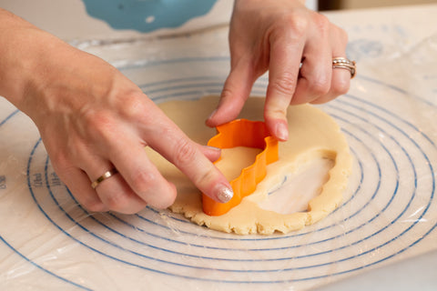 Cookie Mommas cutting out cookies for their cookie decorating cooking class.