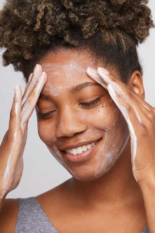 角質ケア洗顔料で顔を洗顔する女性