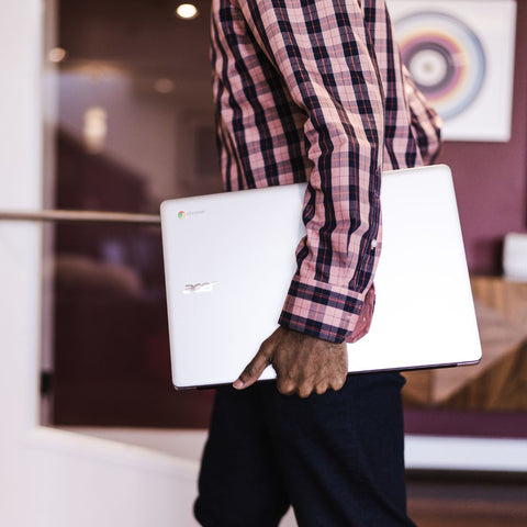 Man carrying a laptop on his hip.