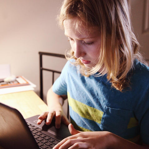 young girl using chromebook