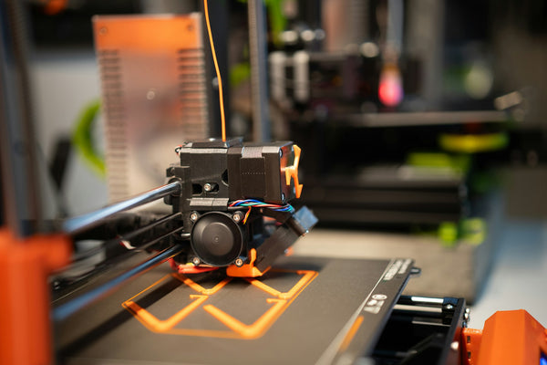 Orange filament being used for 3d printing