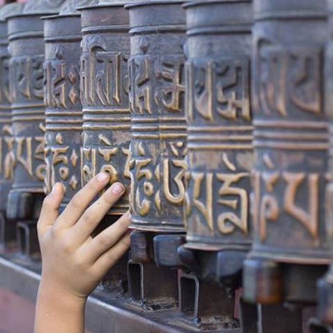 Childs hand on Tibetian Prayer wheels - Tooling for the Skill of Presence