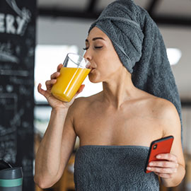 Woman drinking delicious Supple Drink Instant with a towel around chest and head