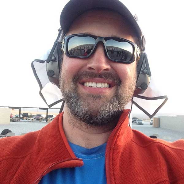 Peter Apatow Supple CEO Founder at shooting range in desert wearing red jacket and sunglasses