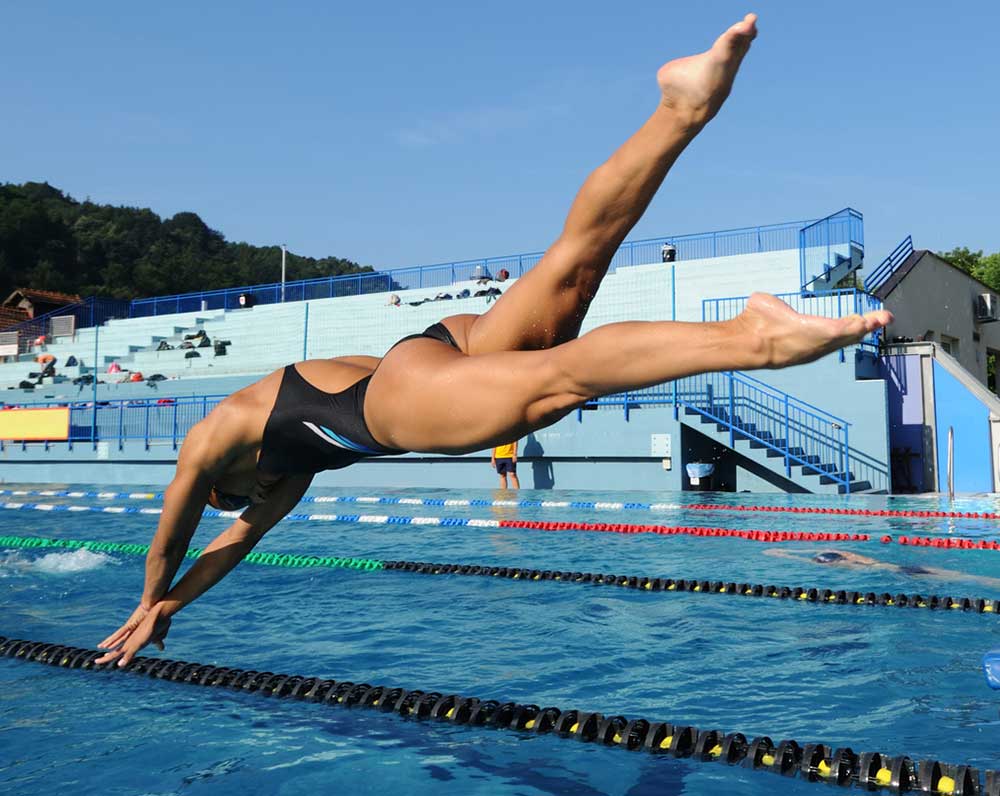 Competitive female swimmer diving into pool. Supple Instant with glucosamine chondriotin inspired.