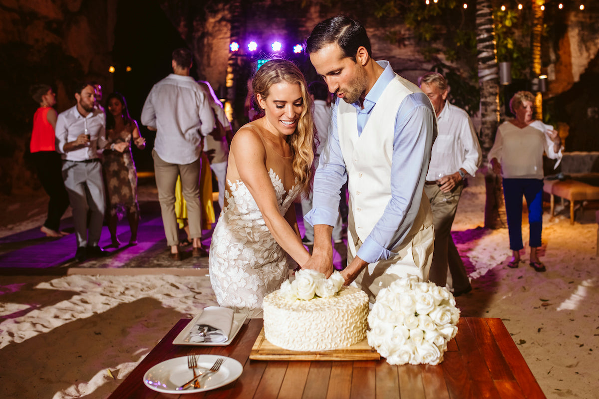 Bride and groom cutting the cake during wedding reception in Mexico