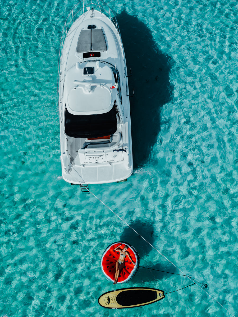 Drone shot of yacht and girl over the float in Cozumel