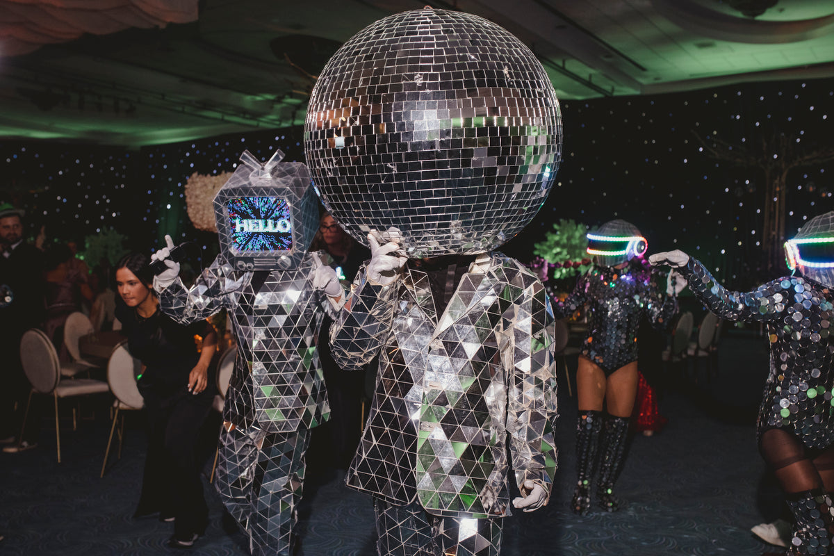 people with brilliant suits with a disco ball in the head