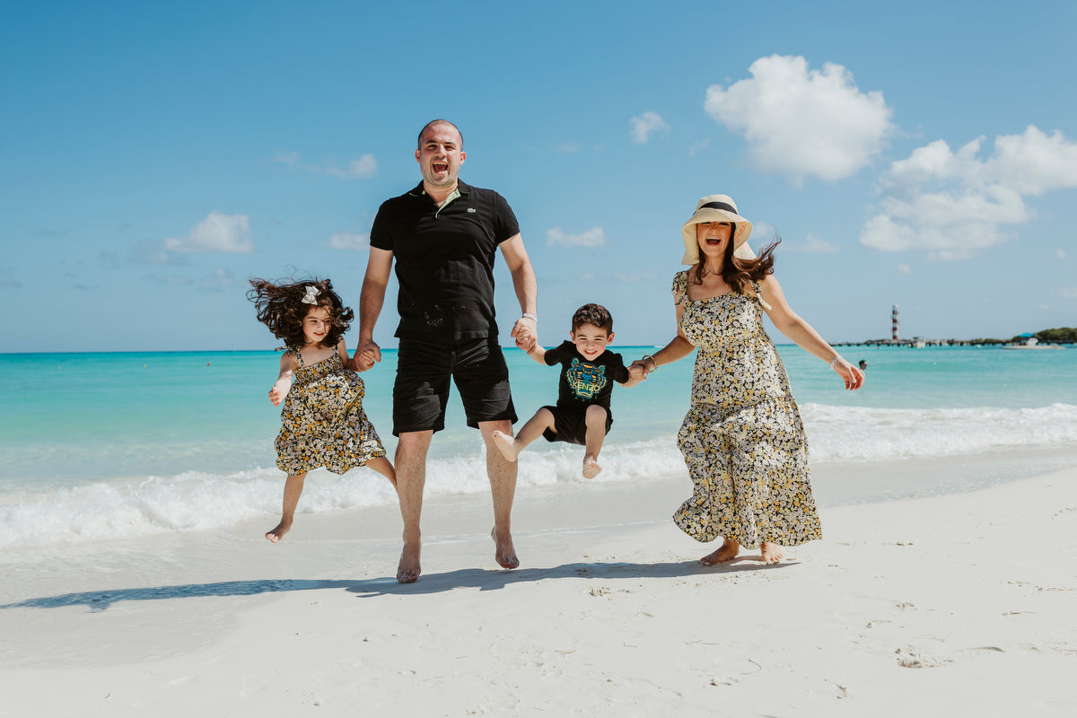 Family jumping and enjoying the beach