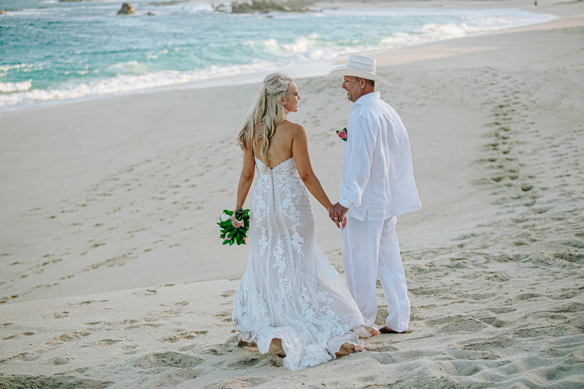 newlyweds walking in the beach of Marquis Los cabos