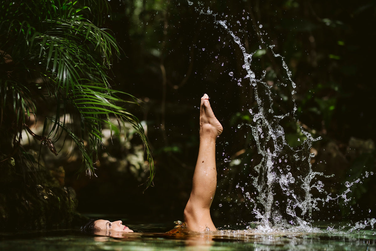 woman floating in the cenote with the leg outside