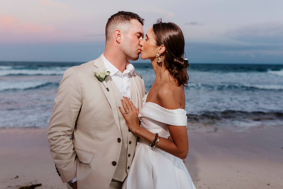 newlyweds kissing on the beach