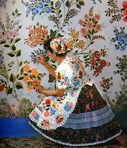Hungarian woman painting flowers on a canvas