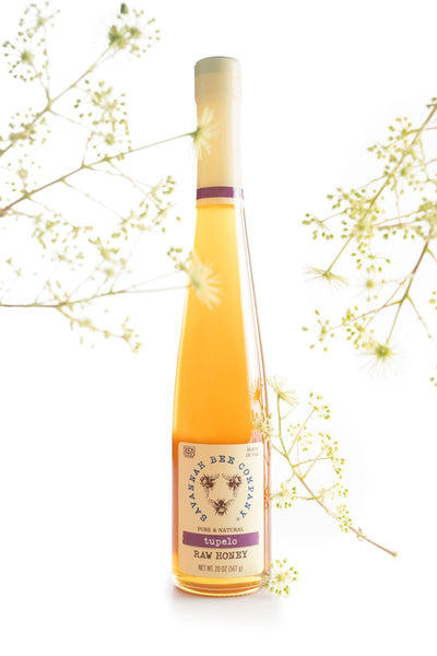 20 ounce tupelo honey flute surrounded by tupelo flowers.