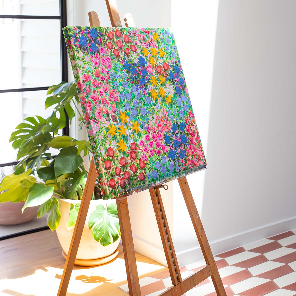 Floral canvas sitting on an easel in a sun-drenched house