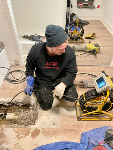 "Plumber from Mele Plumbing Services in Toronto using a camera to inspect a drain."