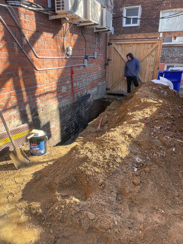 "Plumber from Mele Plumbing Services in Toronto inspecting and maintaining drainage systems."